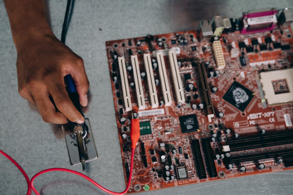An engineer uses a soldering tool on a motherboard, showcasing technology and precision.