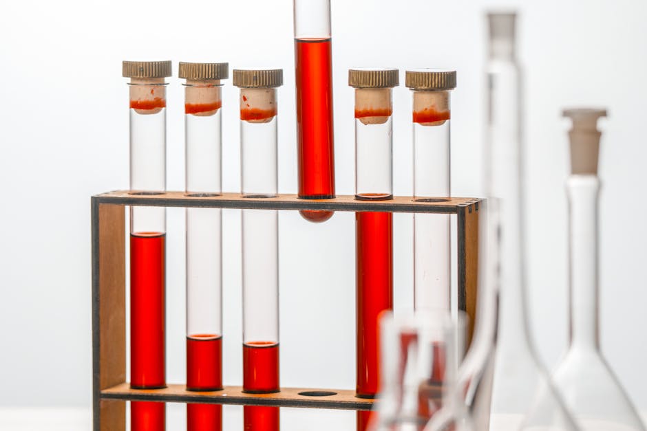 Close-up of test tubes filled with red liquid in a laboratory setting.
